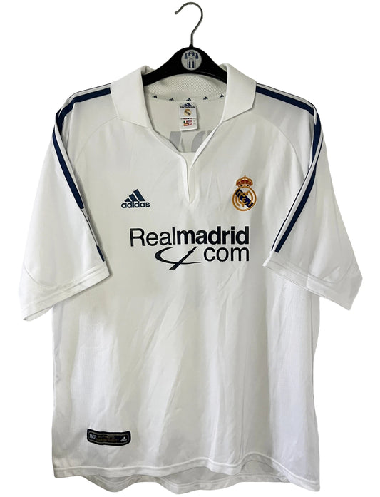 Maillot de foot vintage domicile blanc du real madrid de la saison 2001/2002. On peut retrouver l'équipementier Adidas et le sponsor Real madrid.com. Le maillot est floqué du numéro 5 Zinedine Zidane. Il s'agit d'un maillot authentique d'époque.