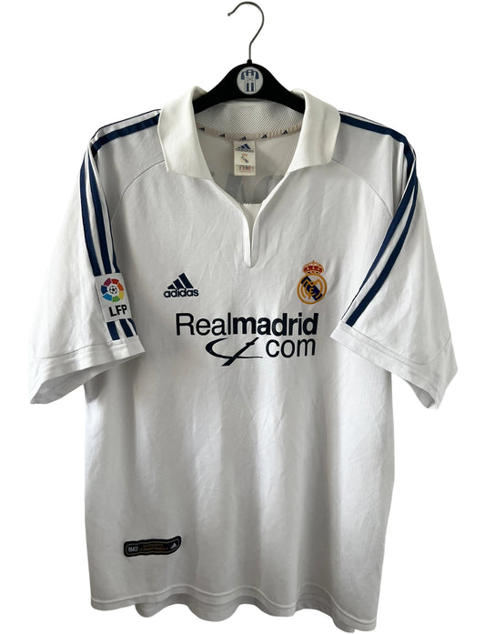 Maillot de foot vintage domicile blanc du real madrid de la saison 2001/2002. On peut retrouver l'équipementier Adidas et le sponsor Real madrid.com. Le maillot est floqué du numéro 5 Zinedine Zidane. Il s'agit d'un maillot authentique d'époque.