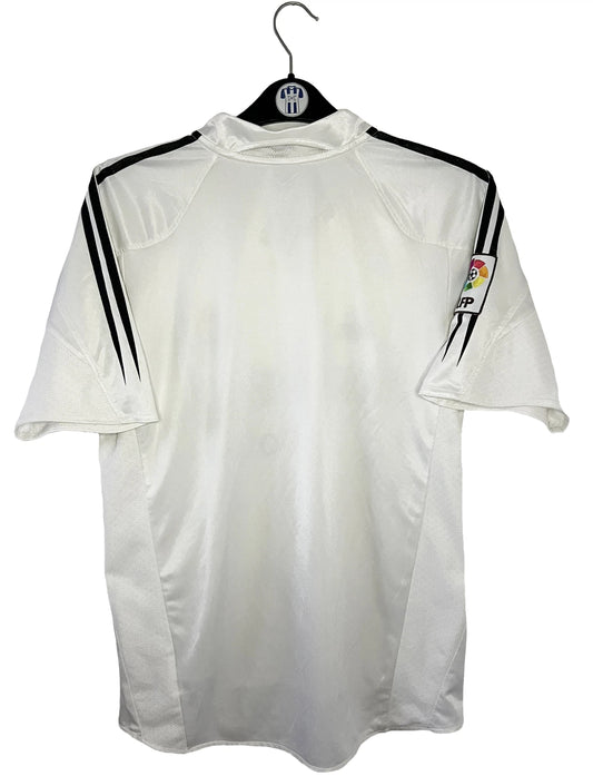 Maillot de foot vintage domicile blanc du real madrid de la saison 2004/2005. On peut retrouver l'équipementier Adidas et le sponsor Siemens. Il s'agit d'un maillot authentique d'époque comportant l'étiquette 367842