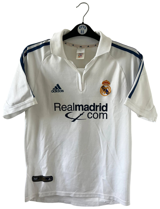 Maillot de foot vintage domicile blanc du real madrid de la saison 2001/2002. On peut retrouver l'équipementier Adidas et le sponsor Rea Madrid. Le maillot est floqué du numéro 5 Zinedine Zidane. Il s'agit d'un maillot authentique d'époque.