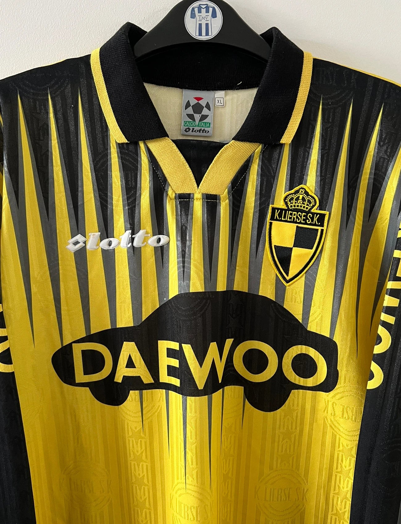 Maillot de foot vintage domicile jaune et noir du SK Lierse saison 1997/1998. On peut retrouver l'équipementier Lotto et le sponsor Daewoo. Il s'agit d'un maillot authentique d'époque.