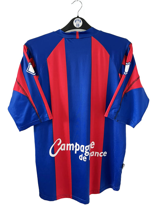 Maillot de foot vintage domicile bleu et rouge du SM Caen de la saison 2006/2007. On peut retrouver l'équipementier Errea et le sponsor Brittany Ferries et GDE. Il s'agit d'un maillot authentique d'époque.