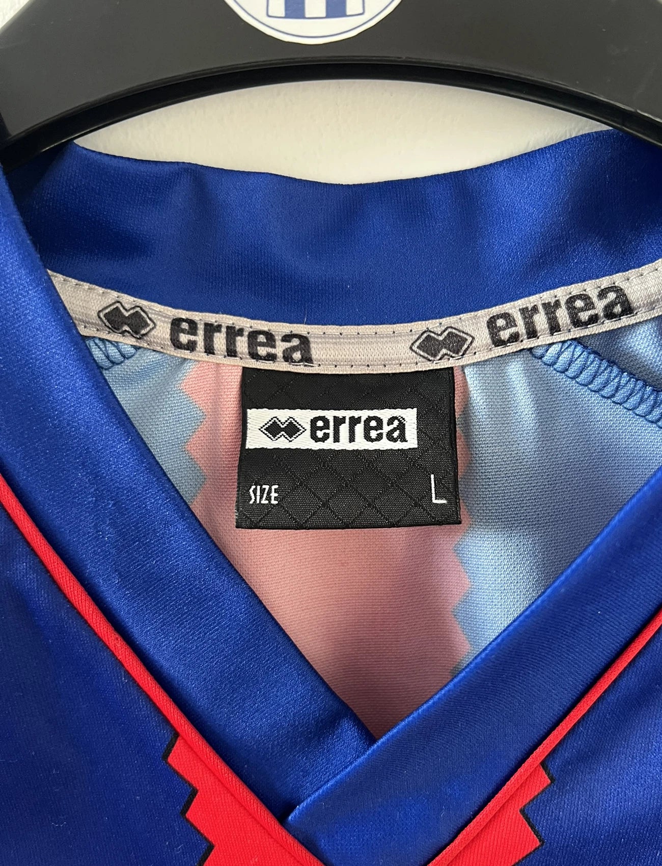 Maillot de foot vintage domicile bleu et rouge du SM Caen édité lors de la finale de la coupe de la Ligue de la saison 2004/2005. On peut retrouver l'équipementier errea et le sponsor isigny sainte mère. Il s'git d'un maillot authentique d'époque.