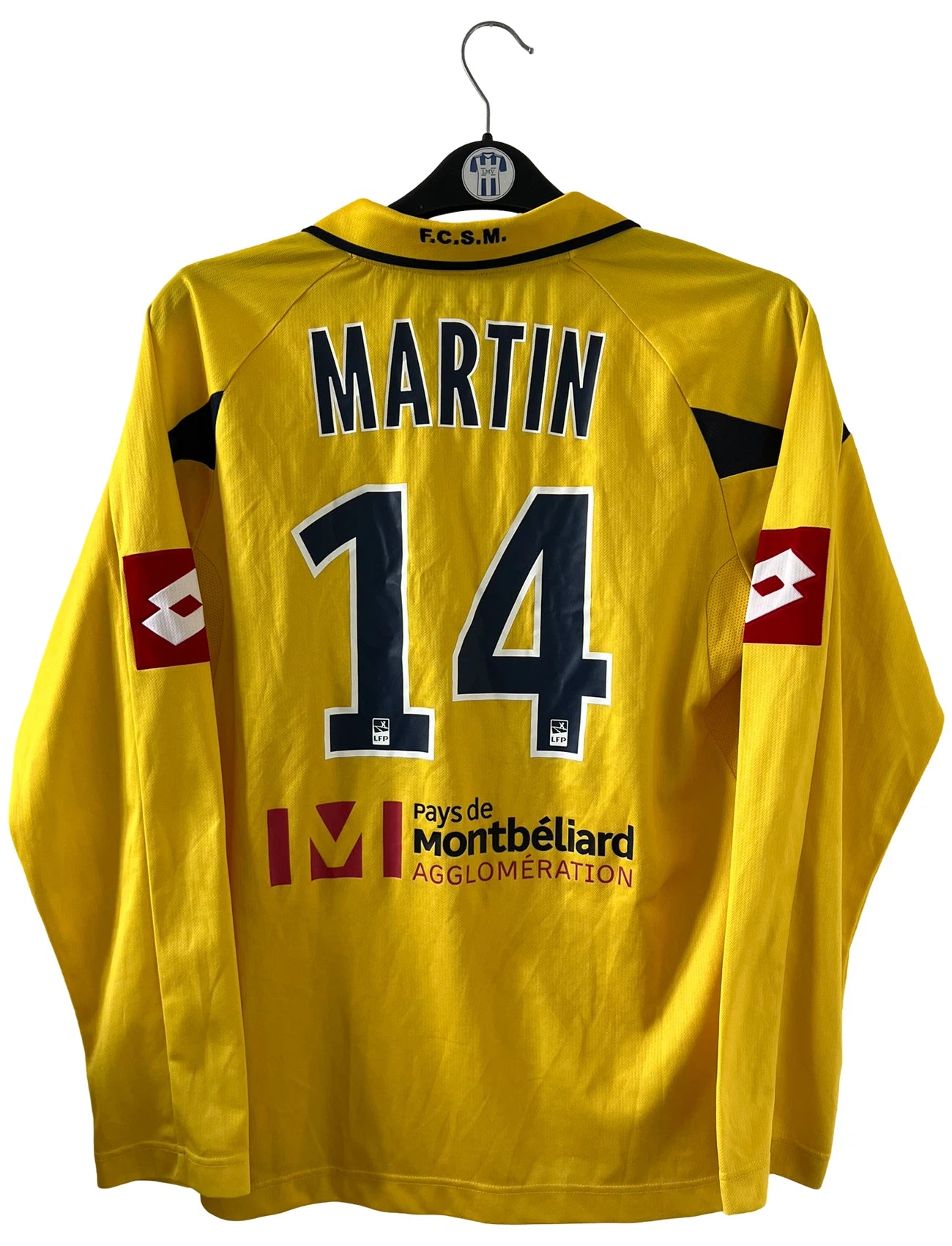 Maillot de foot vintage domicile manche longe jaune de sochaux montbéliard de la saison 2010/2011. On peut retrouver l'équipementier Lotto et le sponsor Peugeot. Le maillot est floqué du numéro 14 Marvin Martin. Il s'agit d'un maillot authentique d'époque.