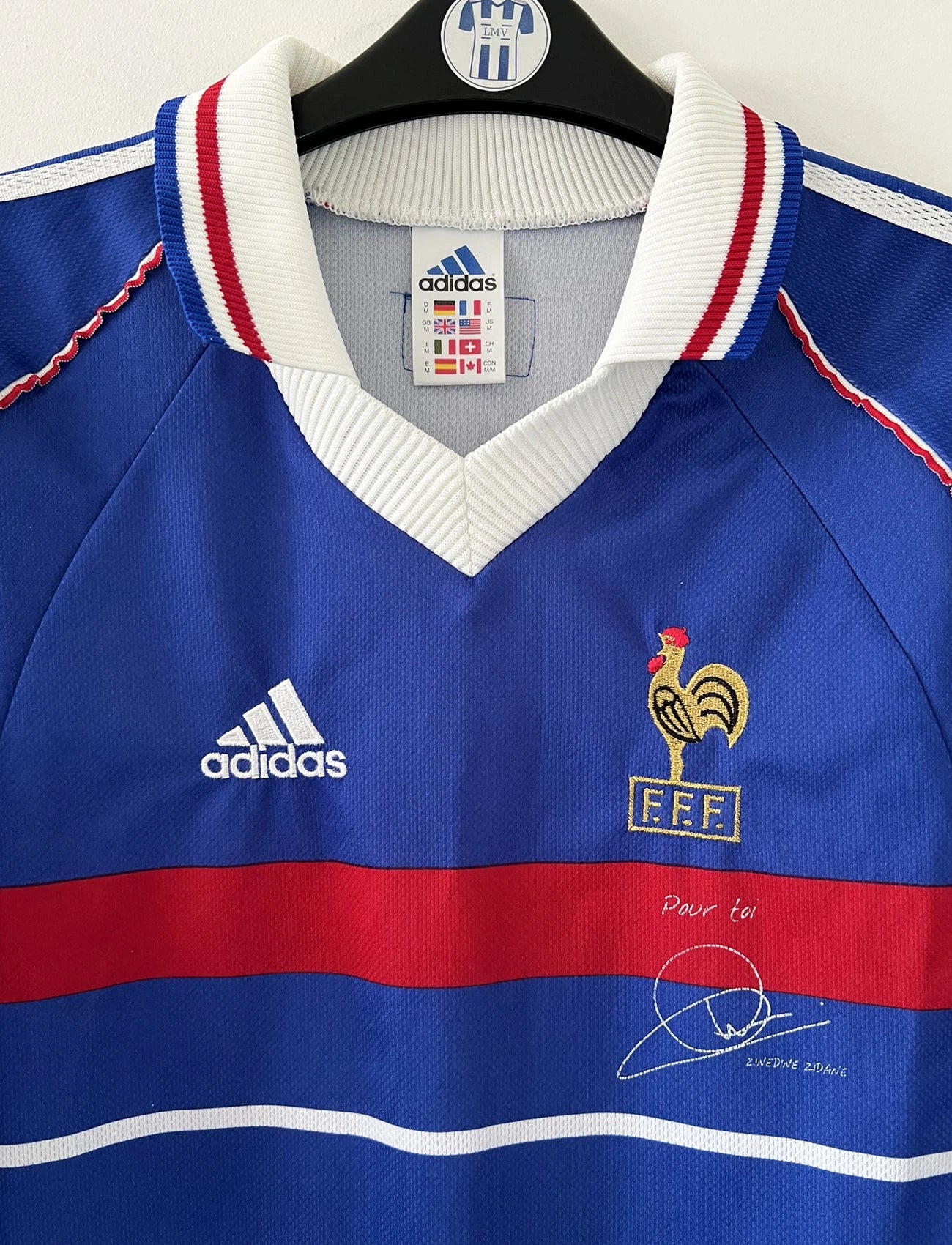 Maillot de foot vintage domicile bleu de l'Equipe de France 1998. On peut retrouver l'équipementier Adidas. Le maillot a été édité avant la finale puisqu'il ne comporte pas l'étoile. Le maillot possède également la signature et la mention "pour toi zinedine zidane". Il s'agit d'un maillot authentique d'époque.