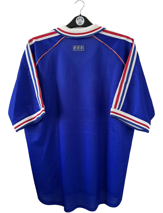 Maillot de foot vintage bleu blanc et rouge domicile de l'équipe de France 1998. On peut retrouver le sponsor adidas. On peut voir le coq sans l'étoile avec la signature "pour toi" de Zinedine Zidane. Il s'agit d'un maillot authentique.