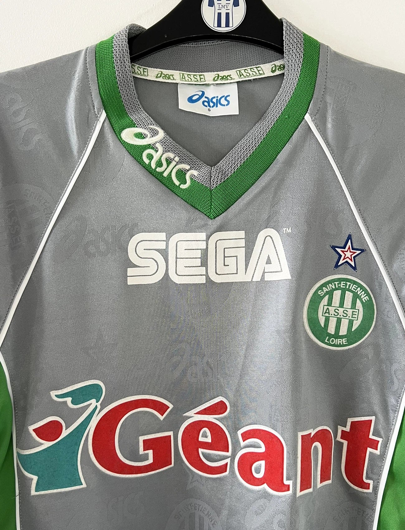 Maillot de foot vintage extérieur gris de l'AS Saint Etienne de la saison 1999/2000. On peut retrouver l'équipementier Asics et les sponsor, Sega, Géant Casino, Dreamcast. Il s'agit d'un maillot authentique d'époque.