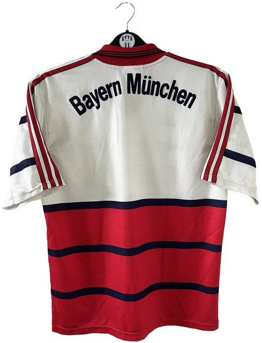 Maillot de foot vintage extérieur blanc et rouge du Bayern Munich de la saison 1998. On peut retrouver l'équipementier adidas et le sponsor Opel. Il s'agit d'un maillot authentique d'époque.
