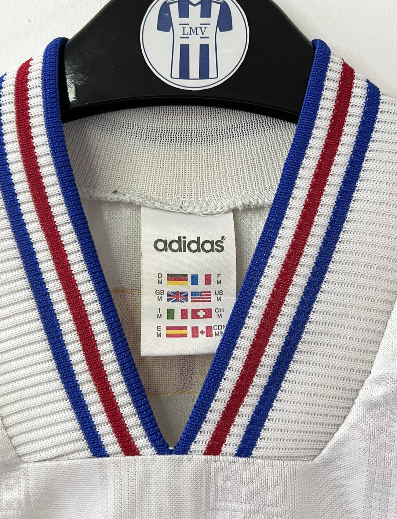 Maillot de foot vintage extérieur blanc de l'équipe de france 1996. On peut retrouver l'équipementier Adidas et le coq sans l'étoile. Il s'agit d'un maillot authentique d'époque.