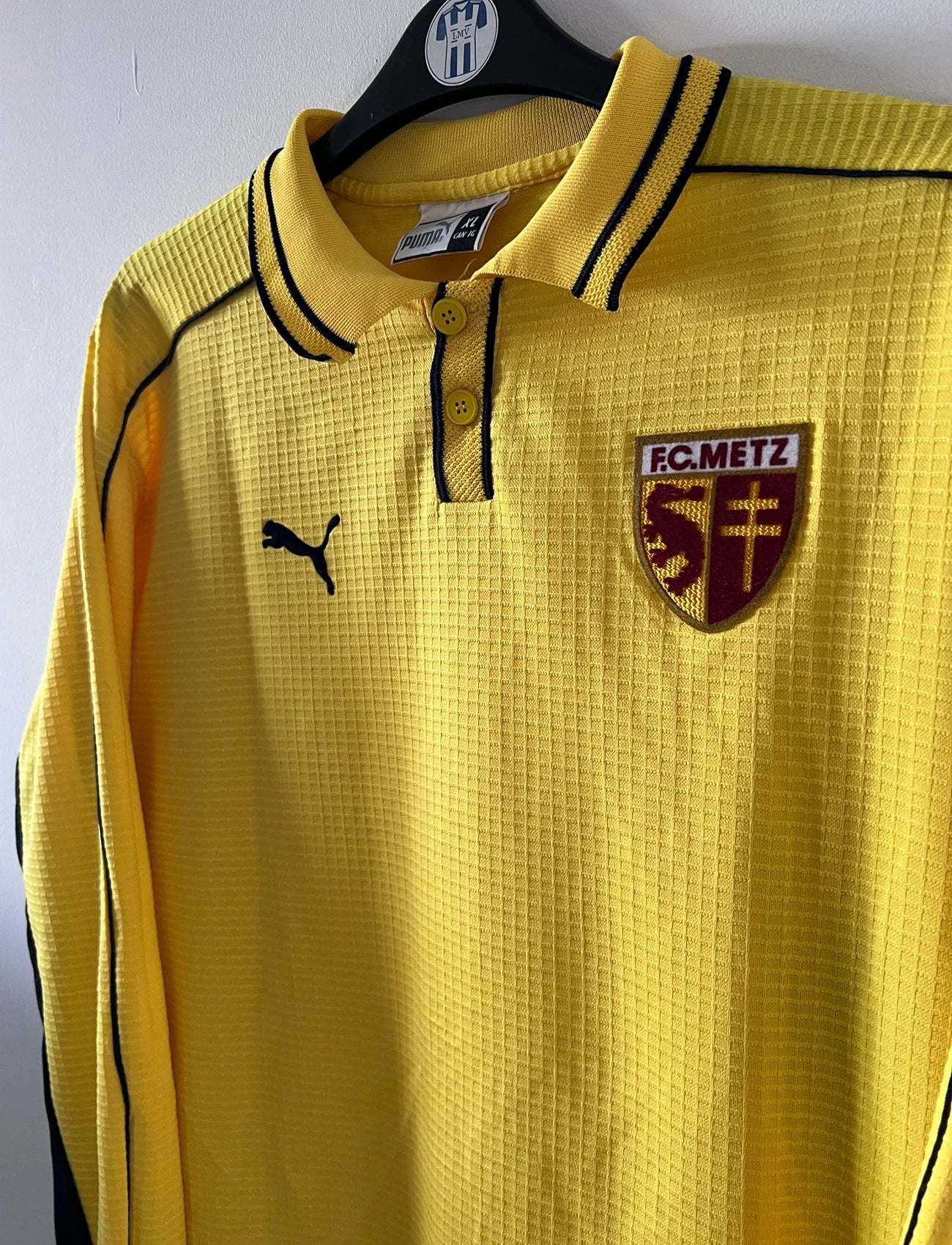 Maillot de foot vintage extérieur jaune du FC Metz de la saison 1999/2000. On peut retrouver l'équipementier Puma. Il s'agit d'un maillot authentique d'époque, issu du stock pro du FC Metz.