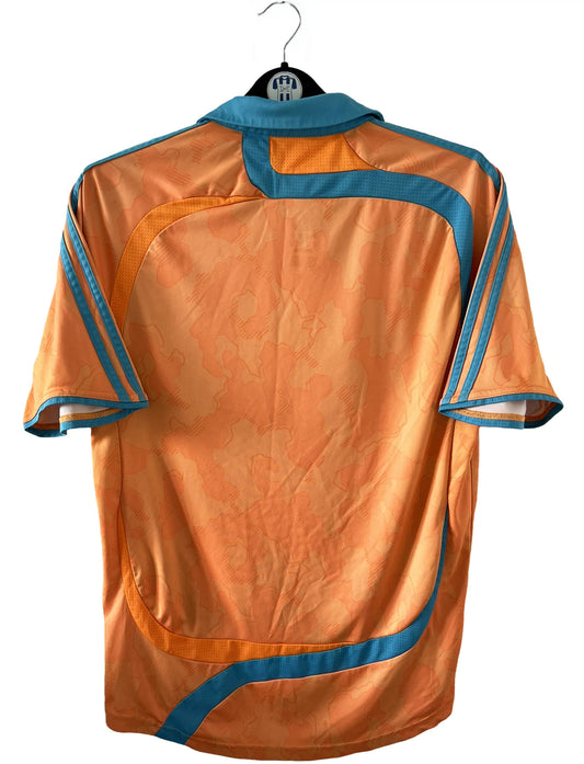 Maillot de foot vintage extérieur orange et bleu de l'OM de la saison 2007/2008. On peut retrouver l'équipementier Adidas et le sponsor Neuf. Il s'agit d'un maillot authentique comportant l'étiquette 695659