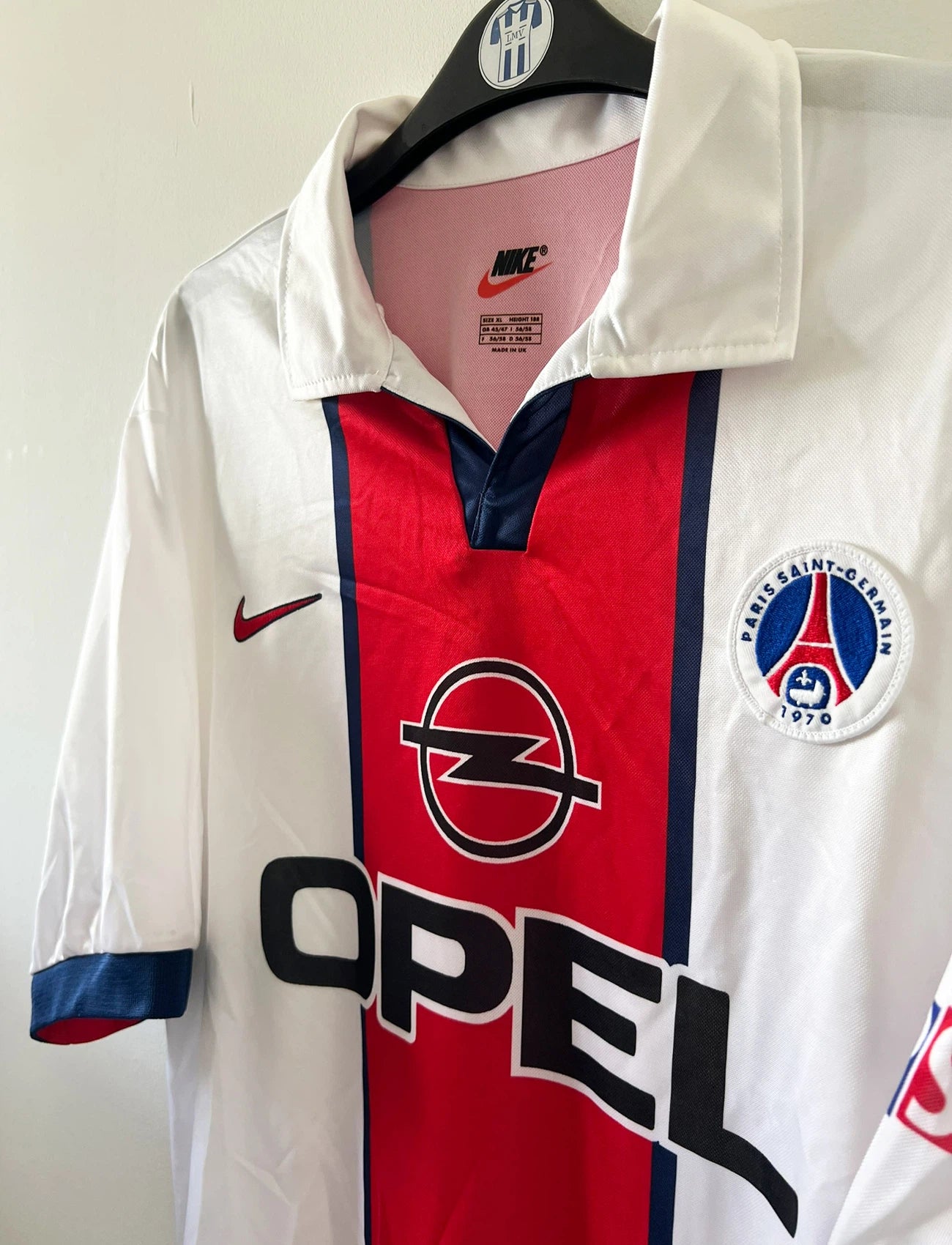 Maillot extérieur PSG blanc et rouge de la saison 1998/1999. On peut retrouver l'équipementier Nike et le sponsor Opel. Il s'agit d'un maillot authentique d'époque.