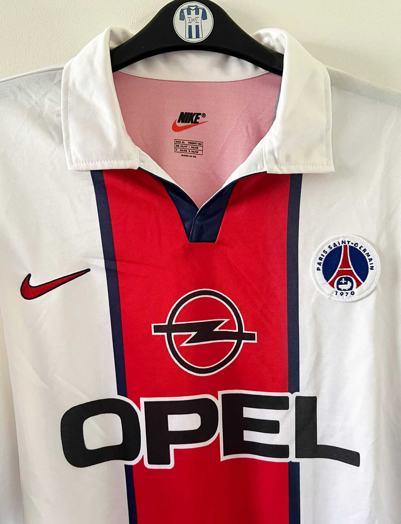 Maillot extérieur PSG blanc et rouge de la saison 1998/1999. On peut retrouver l'équipementier Nike et le sponsor Opel. Il s'agit d'un maillot authentique d'époque.