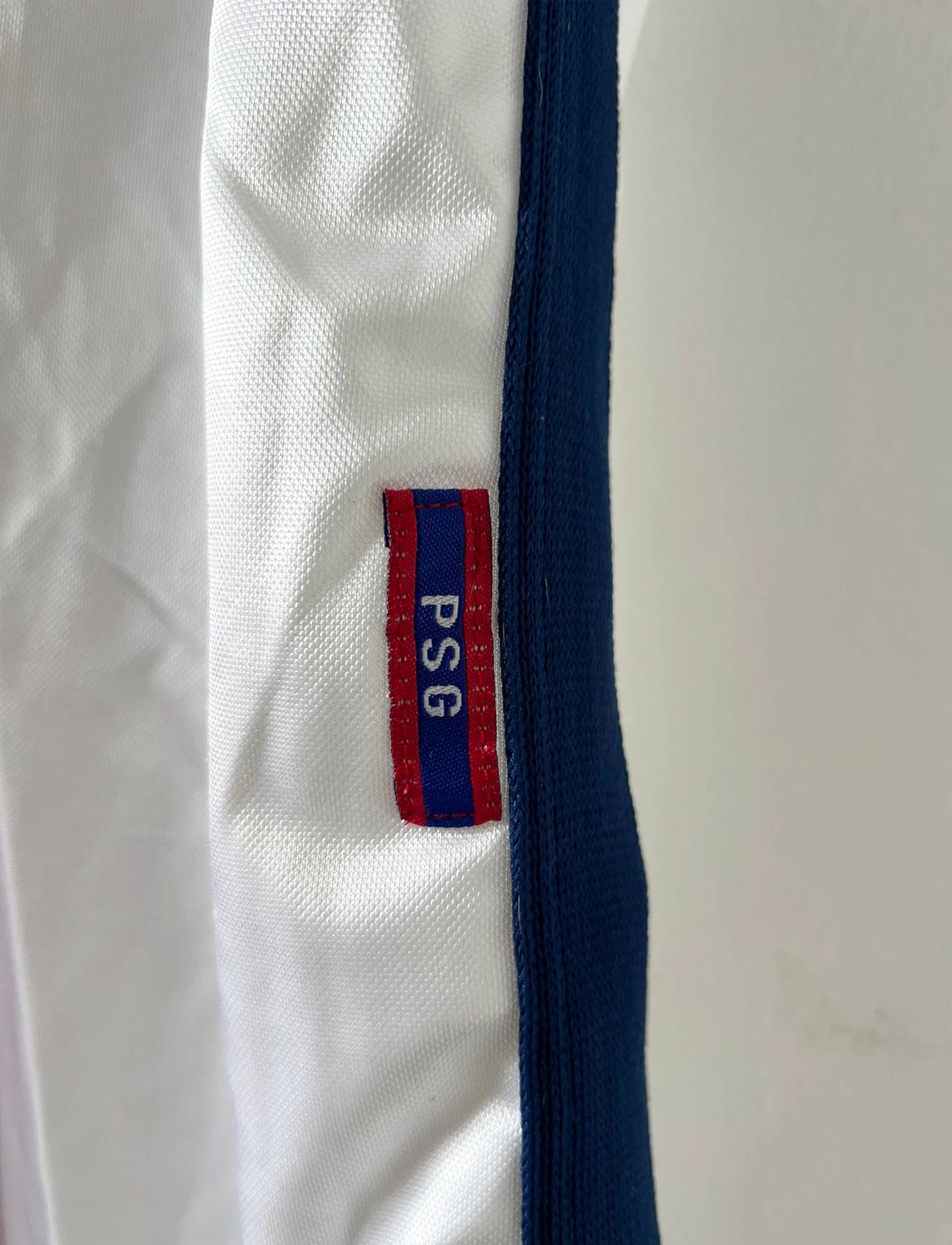 Maillot extérieur PSG blanc et rouge de la saison 1998/1999. On peut retrouver l'équipementier Nike et le sponsor Opel. Il s'agit d'un maillot authentique d'époque.