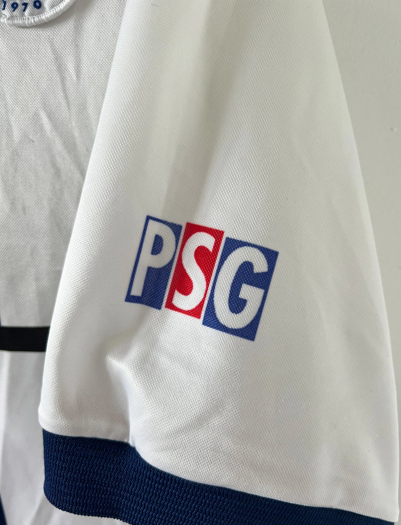 Maillot extérieur PSG blanc et rouge de la saison 1998/1999. On peut retrouver l'équipementier Nike et le sponsor Opel. Il s'agit d'un maillot authentique d'époque.