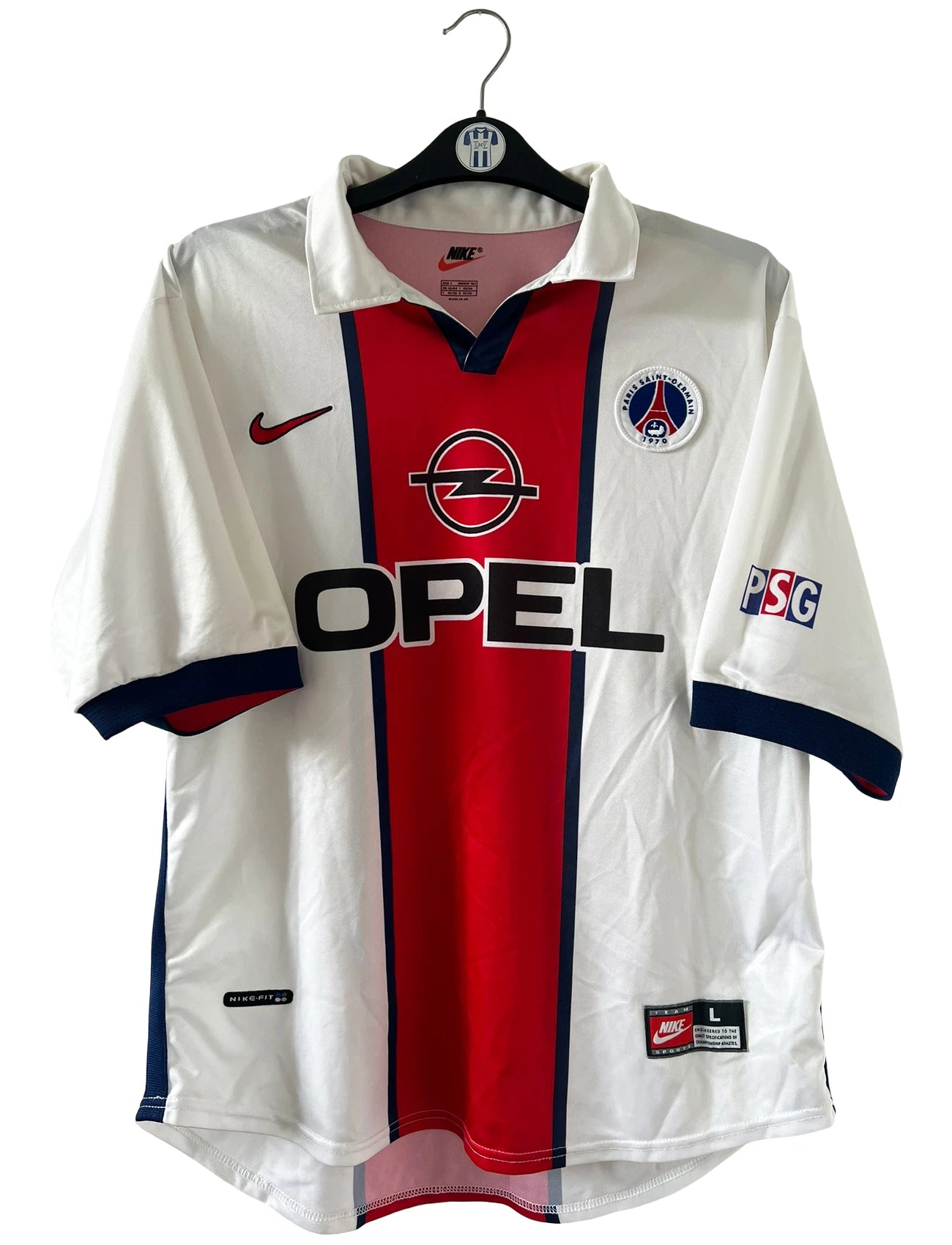 Maillot extérieur PSG blanc et rouge de la saison 1998/1999. On peut retrouver l'équipementier Nike et le sponsor Opel. Il s'agit d'un maillot authentique d'époque.