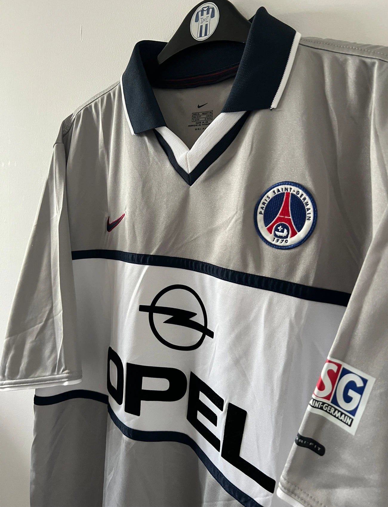 Maillot de foot vintage extérieur gris du PSG de la saison 2000/2001. On peut retrouver l'équipementier Nike et le sponsor Opel. Il s'agit d'un maillot authentique d'époque.