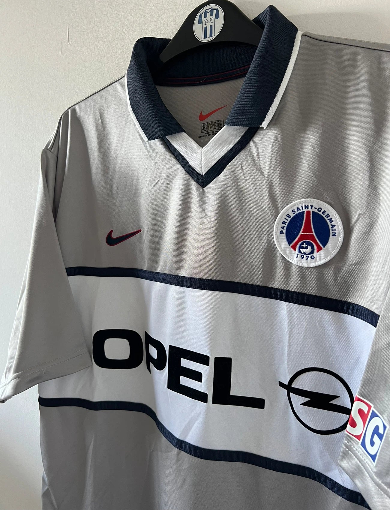 Maillot de foot vintage extérieur gris du PSG de la saison 2000/2001. On peut retrouver l'équipementier Nike et le sponsor Opel. Il s'agit d'un maillot authentique d'époque.