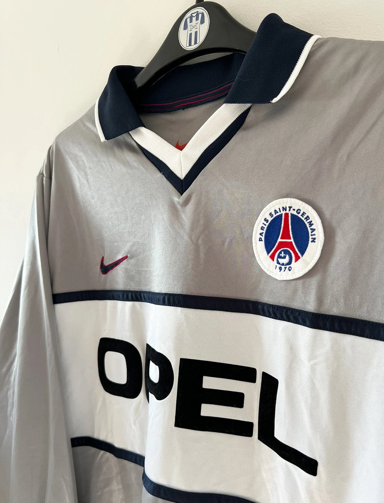 Maillot de foot vintage extérieur gris du PSG de la saison 2000/2001. On peut retrouver l'équipementier Nike et le sponsor Opel. Il s'agit d'un maillot authentique d'époque issu du stock pro du club.