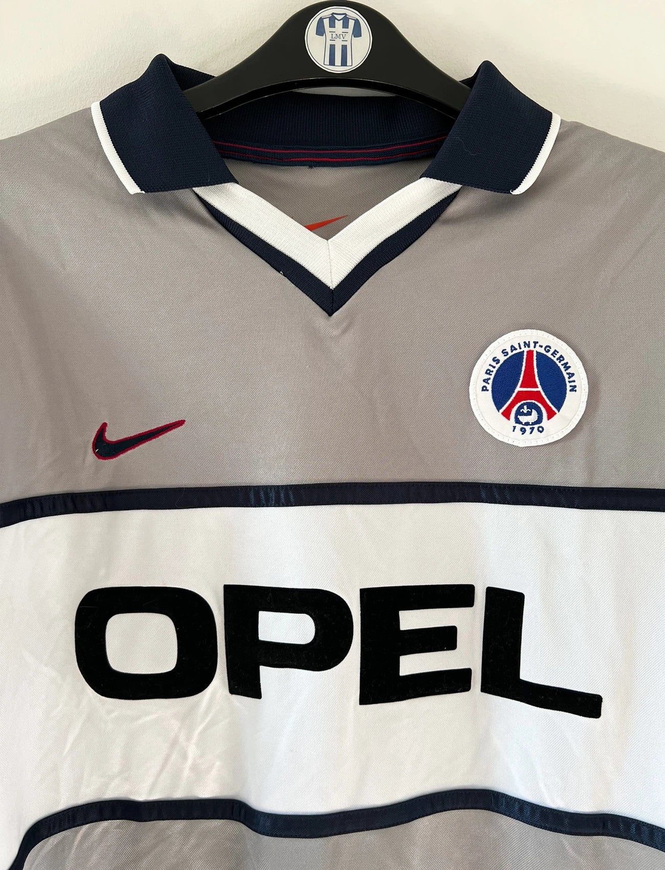 Maillot de foot vintage extérieur gris du PSG de la saison 2000/2001. On peut retrouver l'équipementier Nike et le sponsor Opel. Il s'agit d'un maillot authentique d'époque issu du stock pro du club.