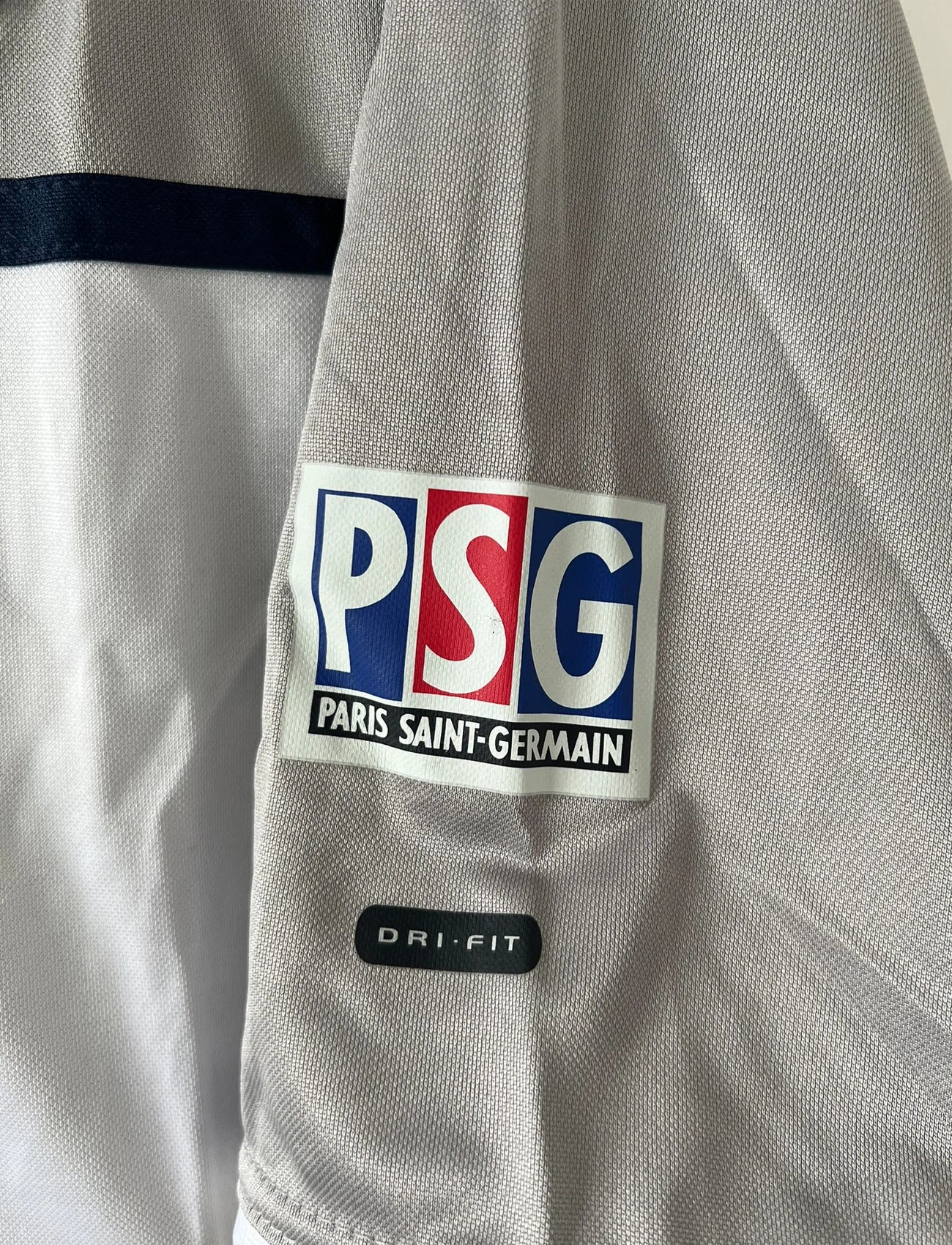 Maillot de foot vintage extérieur gris du PSG de la saison 2000/2001. On peut retrouver l'équipementier Nike et le sponsor Opel. Il s'agit d'un maillot authentique d'époque.
