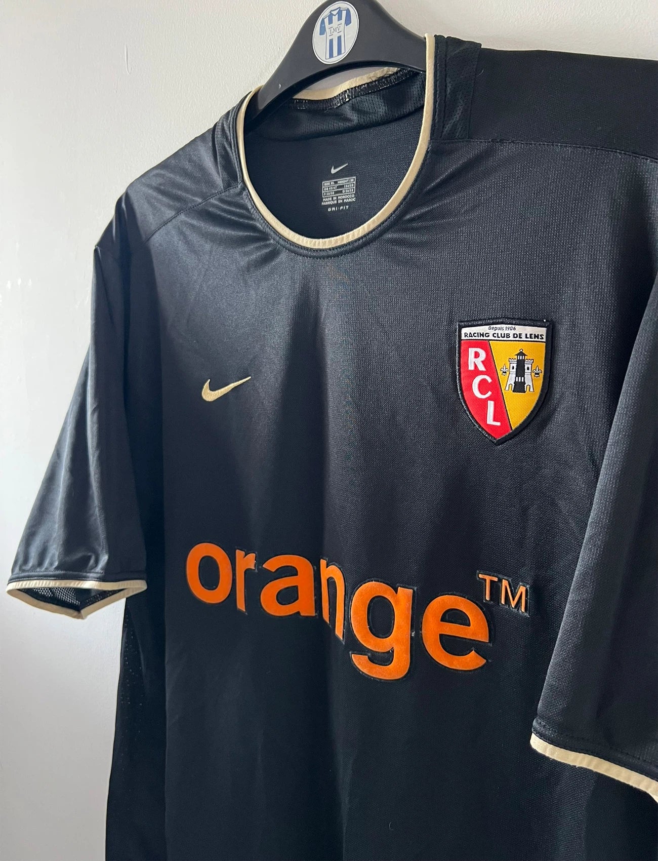 Maillot de foot vintage extérieur noir du RC Lens 2002/2003. On peut retrouver l'équipementier Nike et le sponsor Orange. Il s'agit d'un maillot authentique d'époque.