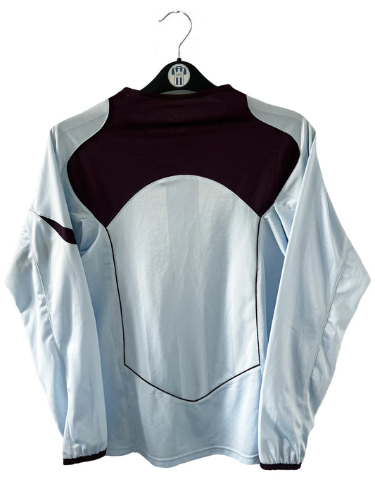 Maillot de foot vintage extérieur bleu et bordeaux du RC Lens de la saison 2004-2005. On peut retrouver l'équipementier Nike. Il s'agit d'un maillot authentique d'époque.