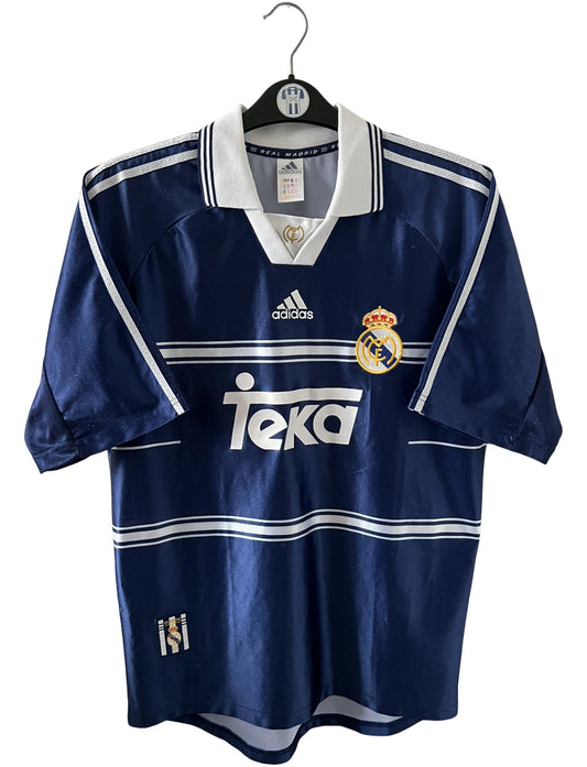 Maillot de foot vintage extérieur bleu du real madrid 1998/1999. On peut retrouver l'équipementier Adidas et le sponsor Teka. Il s'agit d'un maillot authentique d'époque.