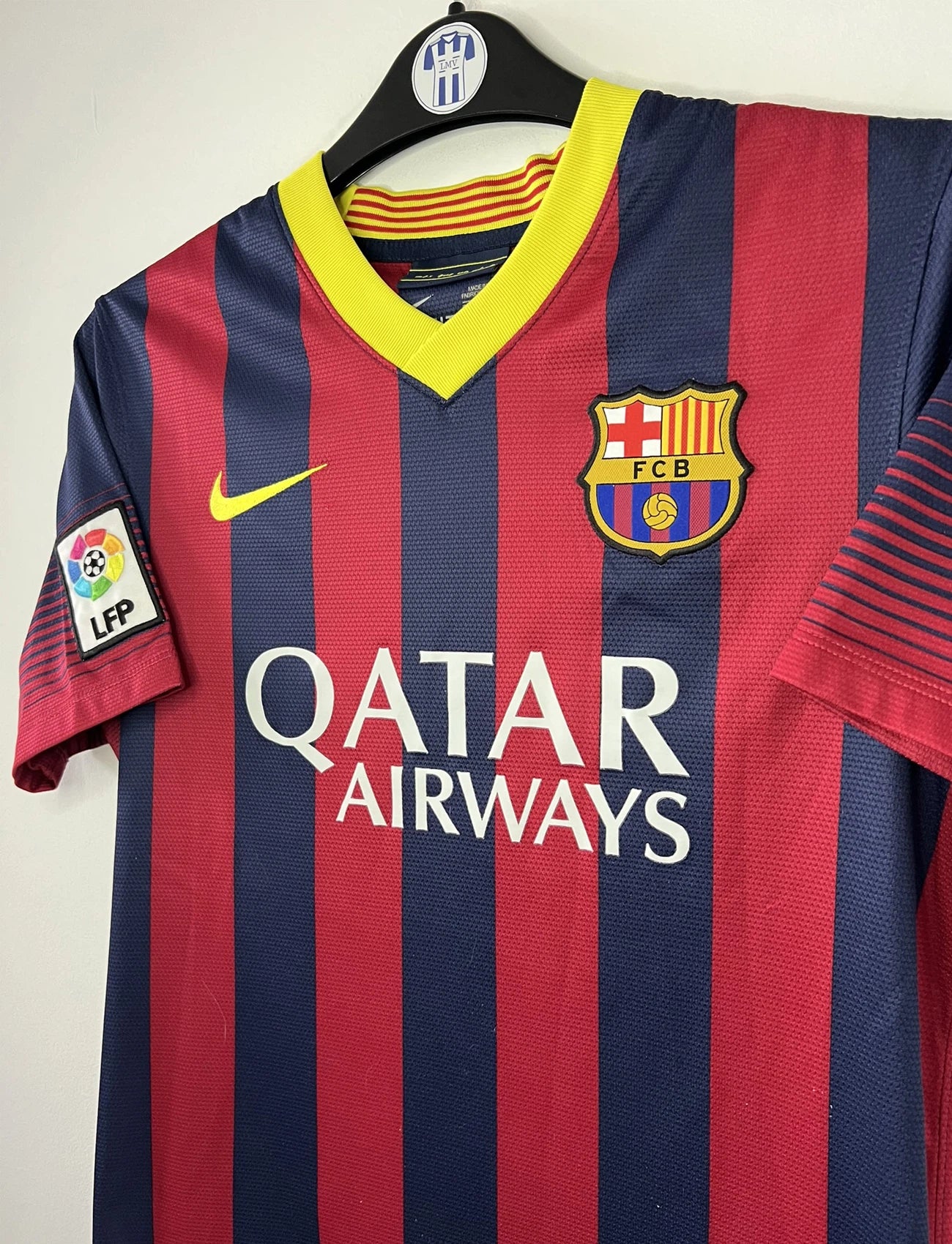 Maillot de foot vintage domicile du FC Barcelone de la saison 2013/14. Le maillot est de couleur rouge et bleu. On peut retrouver l'équipementier nike et le sponsor Qatar Airways. Le maillot est floqué du numéro 11 Neymar. Ils s'agit d'un maillot authentique comportant les numéros 532822-413