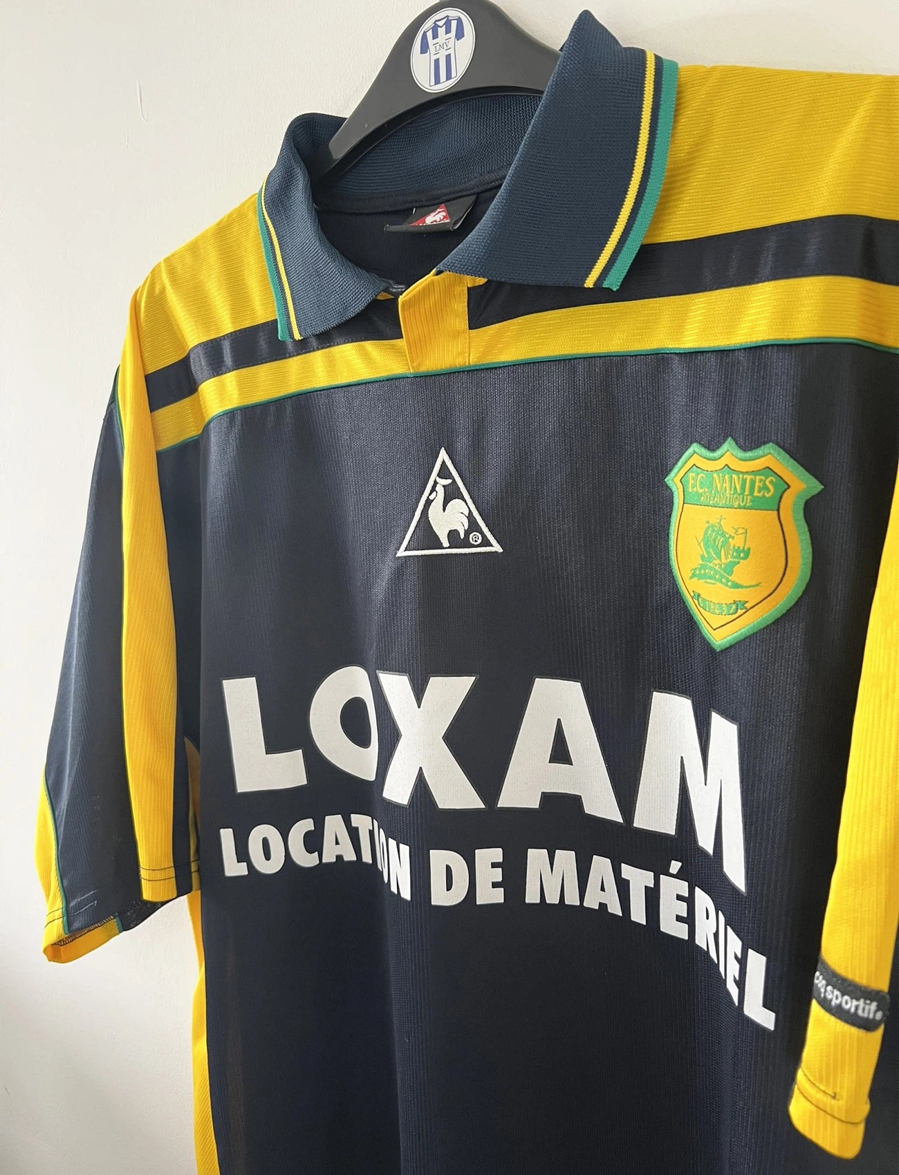 Maillot de foot vintage extérieur bleu et jaune du FC Nantes de la saison 2000-2001. On peut retrouver l'équipementier Le Coq Sportif et le sponsor Loxam. Le maillot est floqué du numéro 8 correspondant à Frédéric Da Rocha. Il s'agit d'un maillot authentique d'époque.
