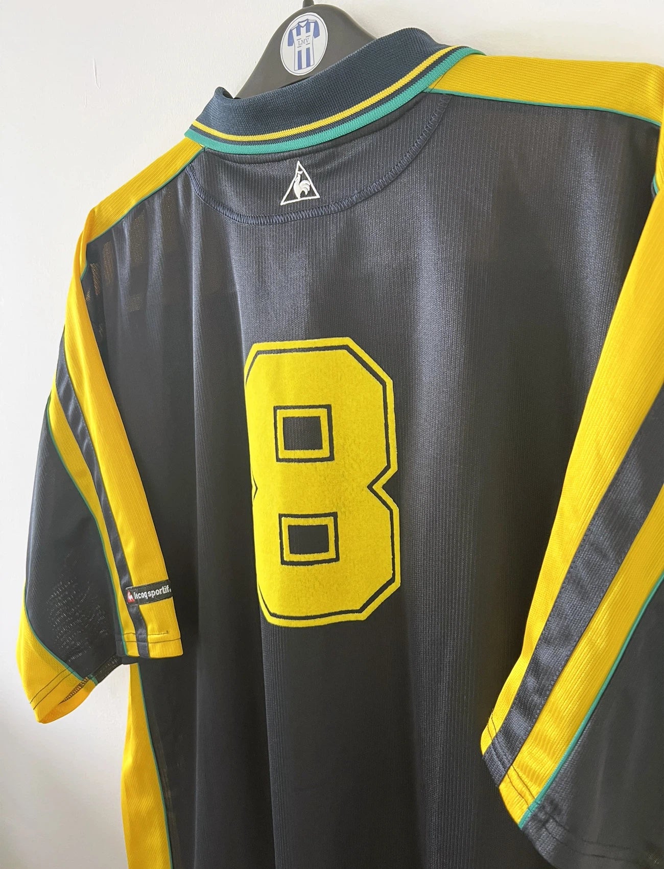 Maillot de foot vintage extérieur bleu et jaune du FC Nantes de la saison 2000-2001. On peut retrouver l'équipementier Le Coq Sportif et le sponsor Loxam. Le maillot est floqué du numéro 8 correspondant à Frédéric Da Rocha. Il s'agit d'un maillot authentique d'époque.
