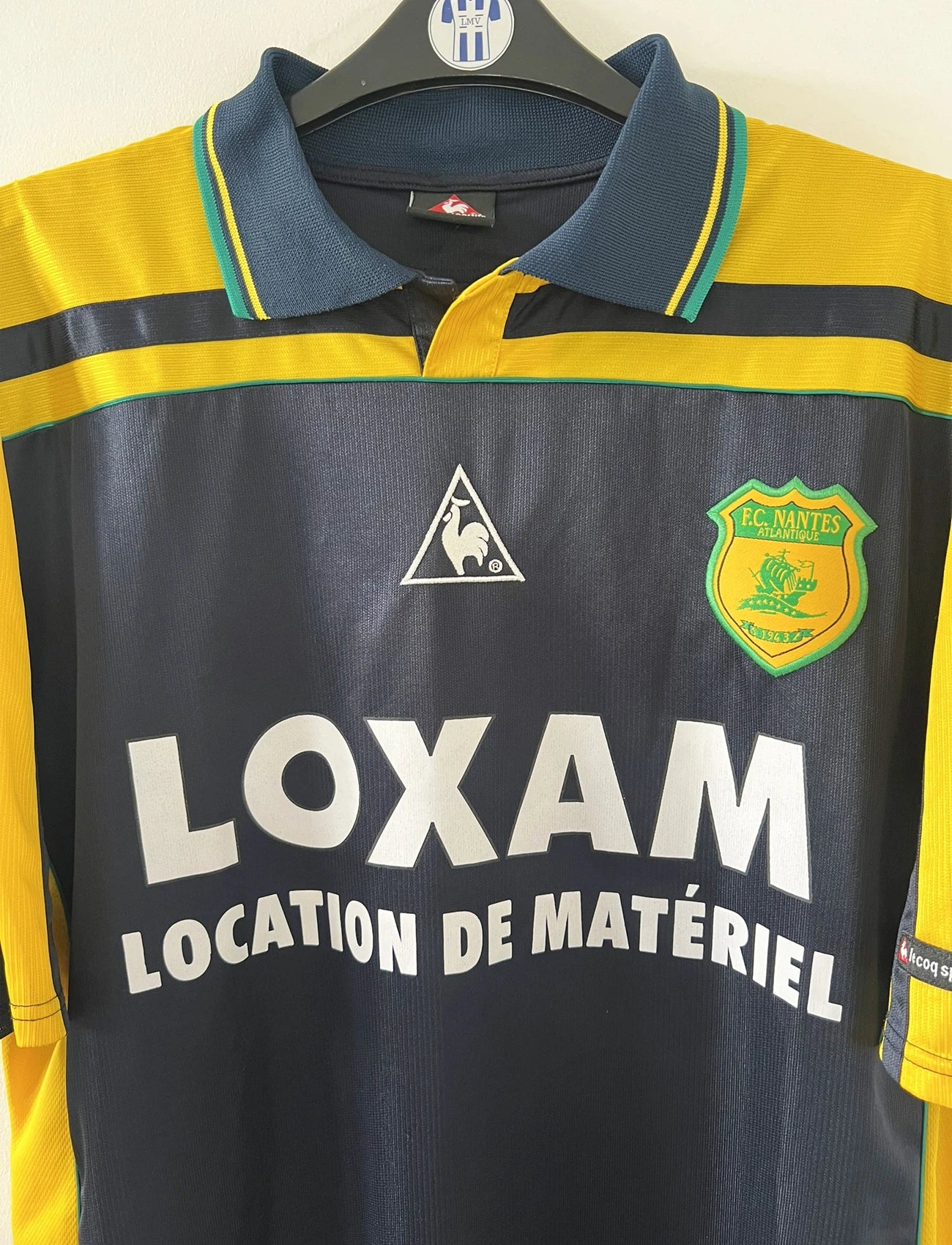 Maillot de foot vintage extérieur bleu et jaune du FC Nantes de la saison 2000-2001. On peut retrouver l'équipementier Le Coq Sportif et le sponsor Loxam. Le maillot est floqué du numéro 8 correspondant à Frédéric Da Rocha. Il s'agit d'un maillot authentique d'époque.