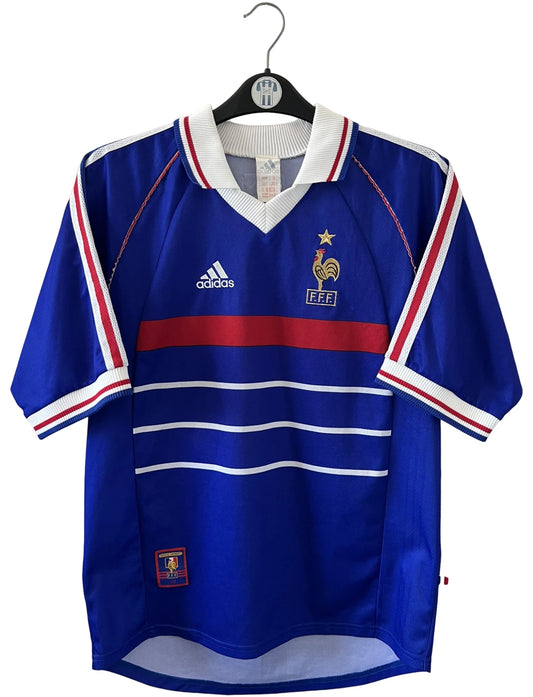 Maillot foot vintage domicile equipe de france 1998 bleu blanc et rouge. On peut retrouver l'équipementier adidas. Il s'agit d'un maillot authentique d'époque. Le maillot est floqué du numéro 10 Zinedine Zidane