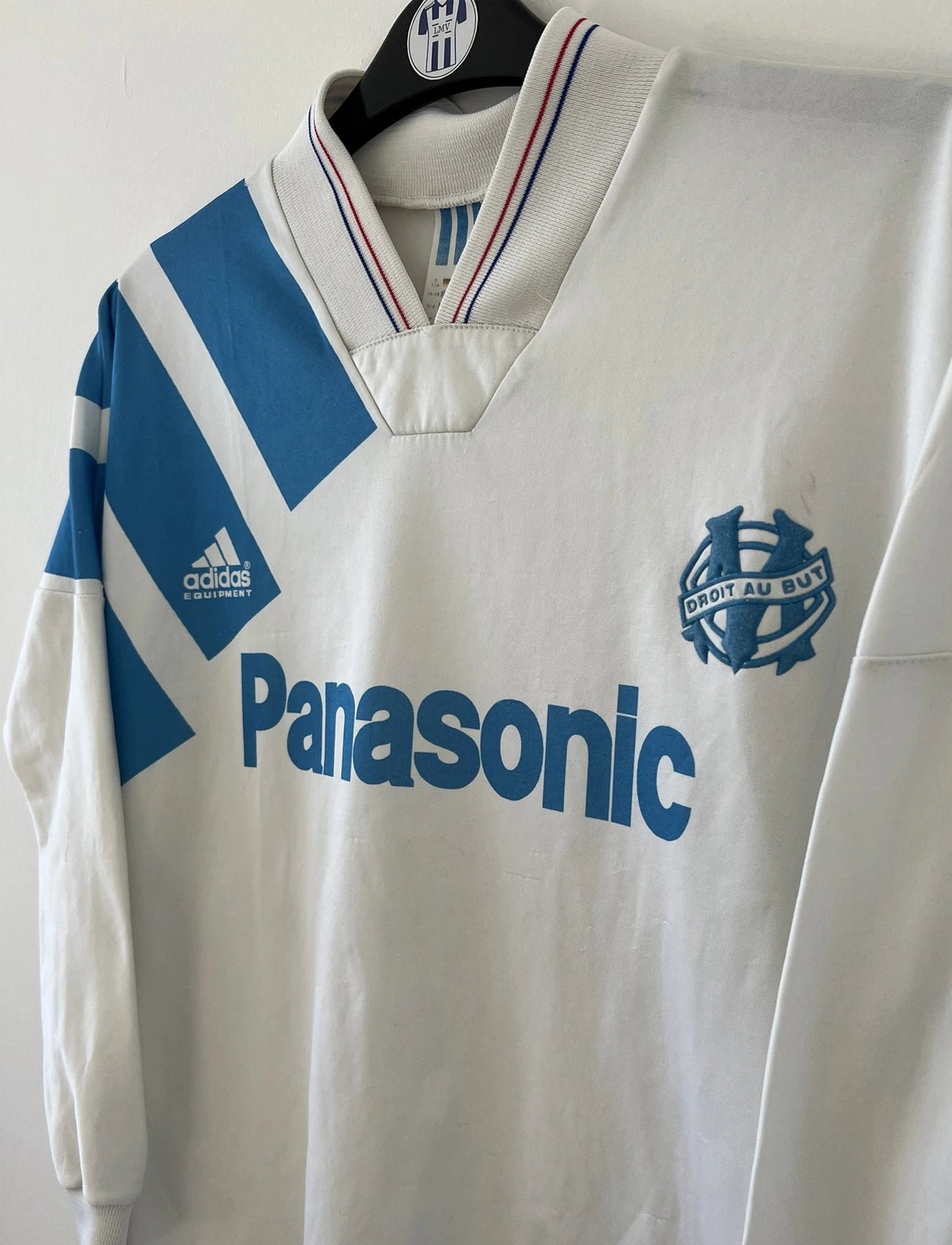 Maillot de foot vintage de l'OM de la saison 1991/1992. Il s'agit du maillot domicile blanc et bleu. On peut retrouver l'équipementier adidas et le sponsor panasonic. Il s'agit d'un maillot authentique d'époque.