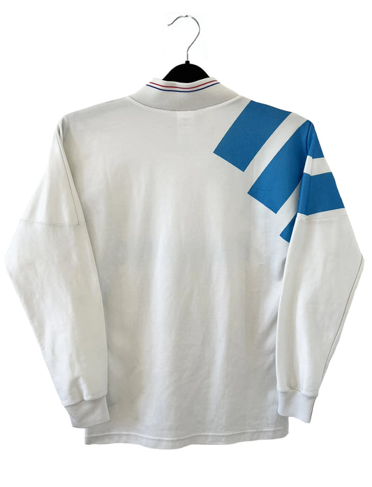 Maillot de foot vintage de l'OM de la saison 1991/1992. Il s'agit du maillot domicile blanc et bleu. On peut retrouver l'équipementier adidas et le sponsor panasonic. Il s'agit d'un maillot authentique d'époque.