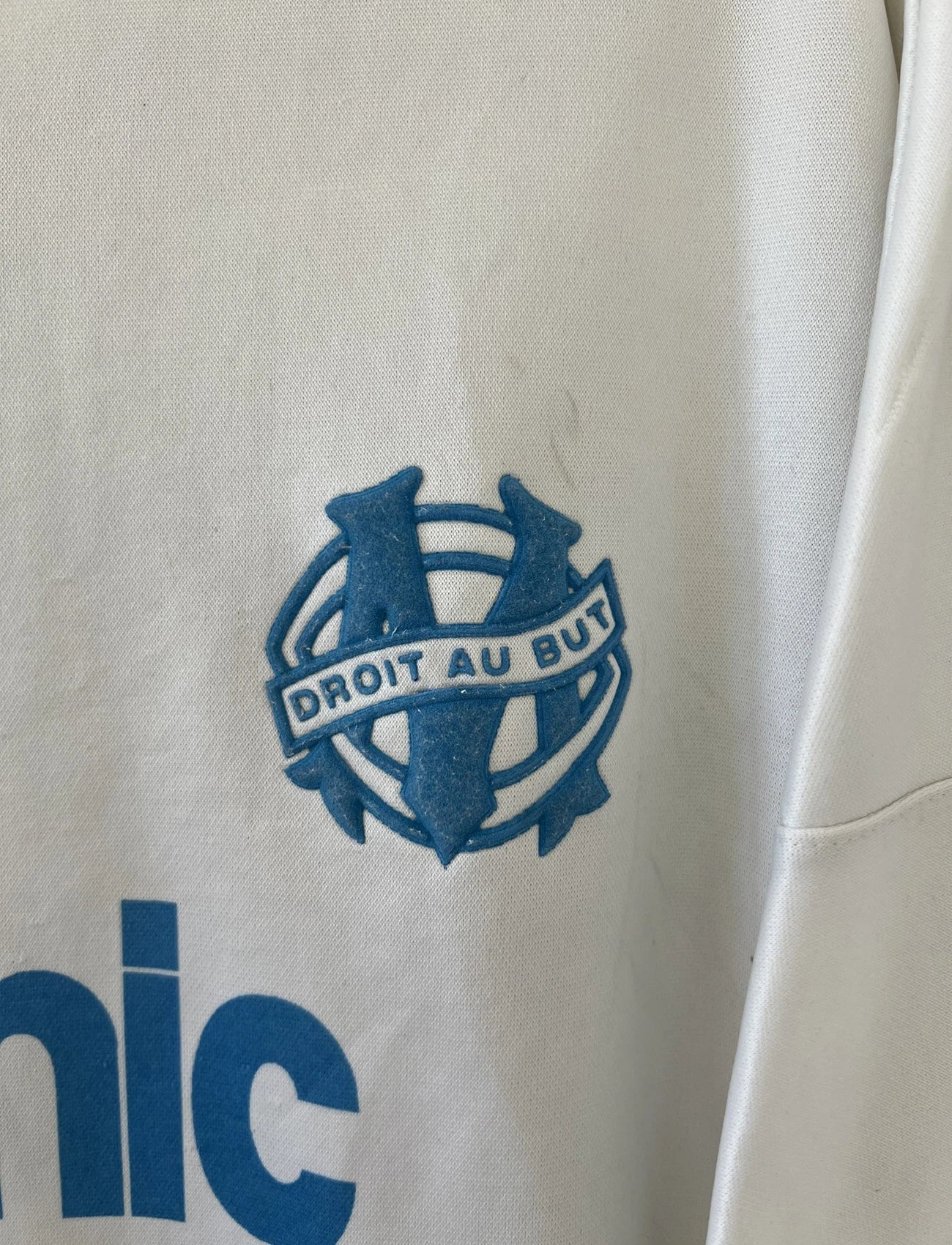 Maillot de foot vintage de l'OM de la saison 1991/1992. Il s'agit du maillot domicile blanc et bleu. On peut retrouver l'équipementier adidas et le sponsor panasonic. Il s'agit d'un maillot authentique d'époque.