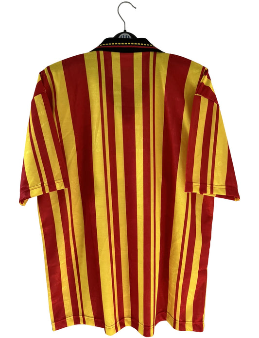 Maillot de foot vintage domicile rouge et jaune du RC Lens de la saison 1995/1996. On peut retrouver l'équipementier Olympic et le sponsor Shopi. Il s'agit d'un maillot authentique d'époque.