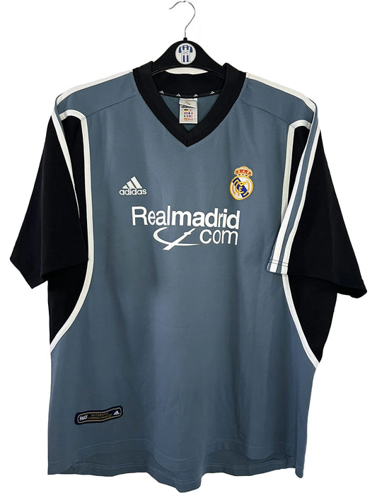 Maillot de foot vintage third gris du real madrid de la saison 2001-2002. On peut retrouver l'équipementier Adidas et le sponsor RealMadrid.com. Le maillot est floqué du numéro 5 Zinedine Zidane. Il s'agit d'un maillot authentique d'époque.