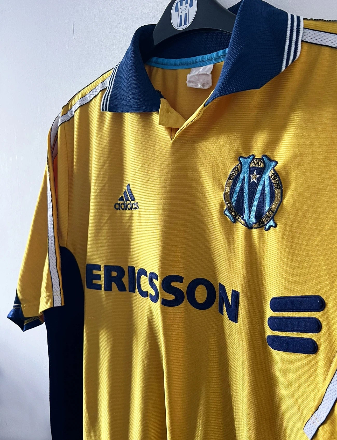 Maillot de foot vintage third doré de l'OM saison 1998/1999. On peut retrouver l'équipementier Adidas et le sponsor Ericsson. Il s'agit d'un maillot authentique d'époque.