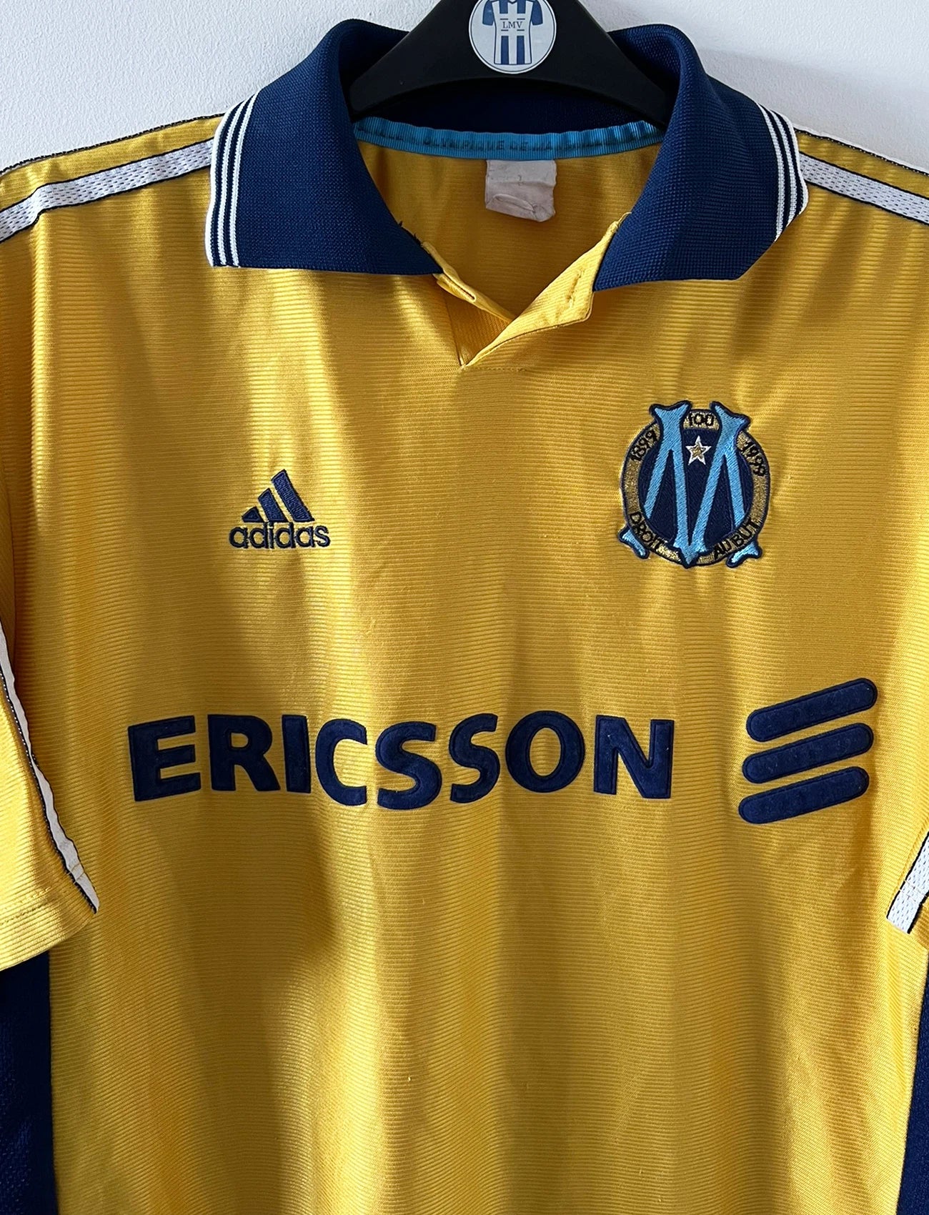 Maillot de foot vintage third doré de l'OM saison 1998/1999. On peut retrouver l'équipementier Adidas et le sponsor Ericsson. Il s'agit d'un maillot authentique d'époque.