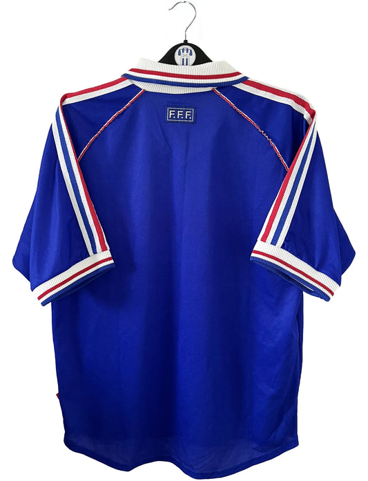 Maillot de foot vintage bleu, blanc et rouge de l'équipe de france 1998. On peut retrouver l'équipementier adidas. Il s'agit d'un maillot authentique édité avant la finale de la coupe du monde car celui-ci ne possède pas l'étoile.