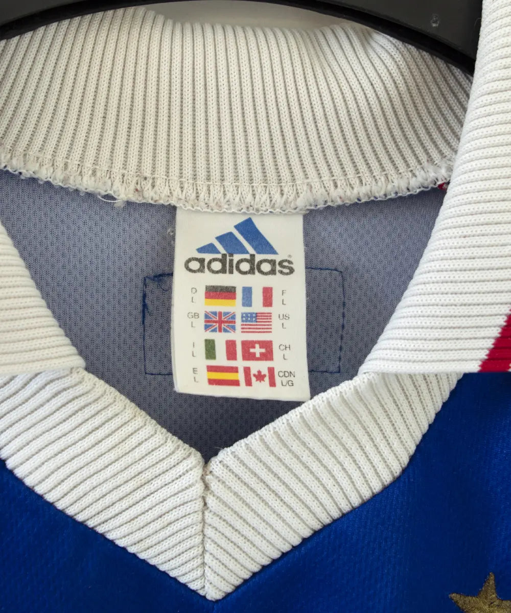 Maillot domicile bleu blanc et rouge de l'équipe de france 1998. On peut retrouver l'équipementier adidas. Le maillot est floqué du numéro 10 Zinedine zidane