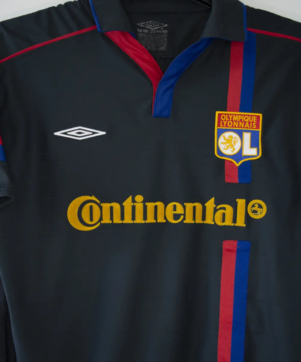 Maillot vintage extérieur noir de l'OL de la saison 2003-2004. On peut retrouver l'équipementier umbro et le sponsor continental.