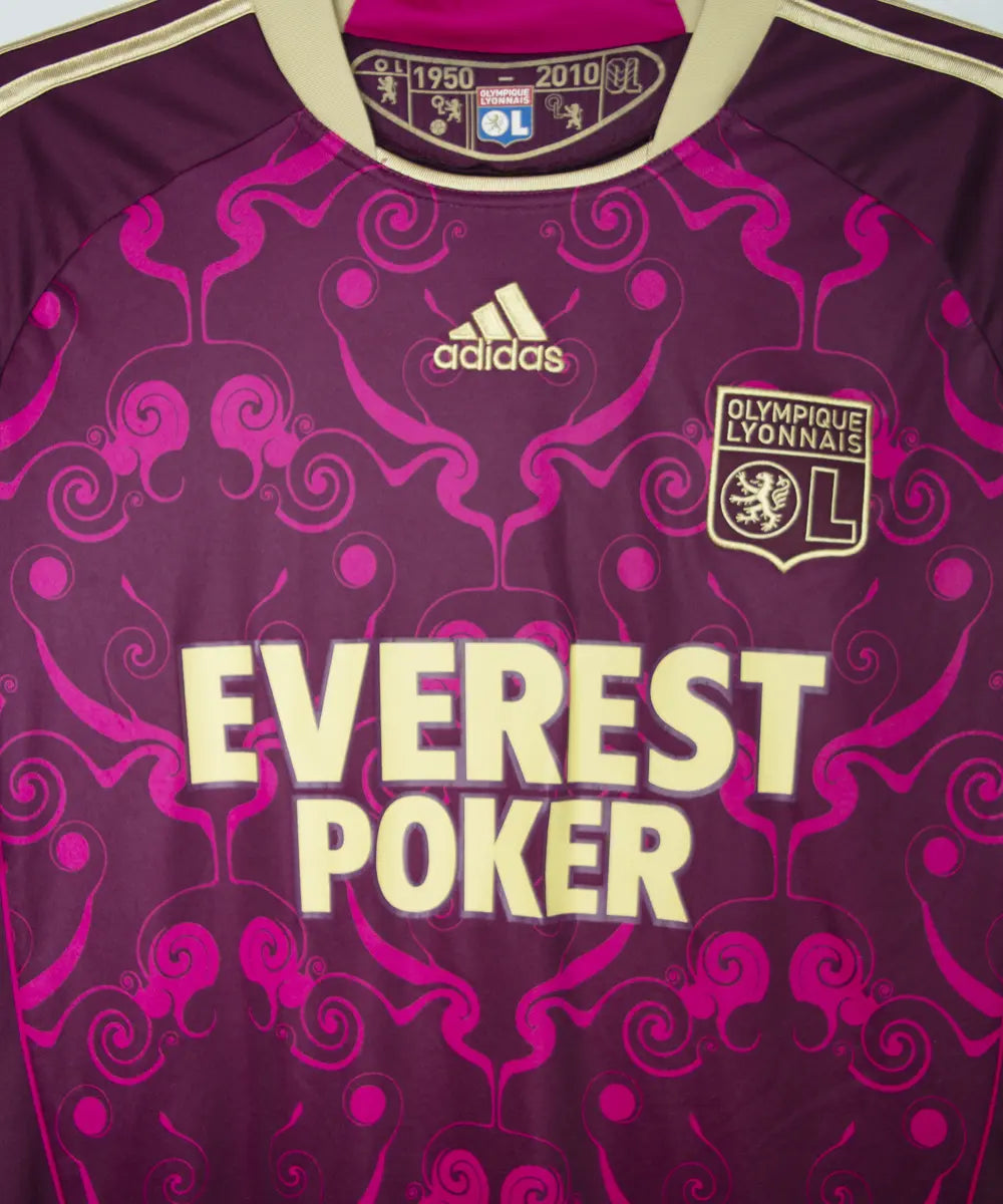 Maillot extérieur de l'ol de la saison 2010-2011. Le maillot est de couleur violet et dorée. On peut retrouver l'équipementier adidas et le sponsor everest poker