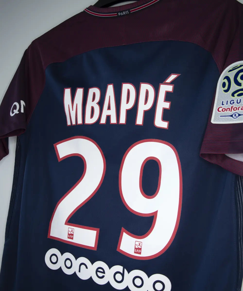 Maillot domicile du psg de la saison 2017-2018 de couleur bleu et rouge. On peut retrouver l'équipementier nike et le sponsor fly emirates. Le maillot est floqué du numéro 29 Mbappé