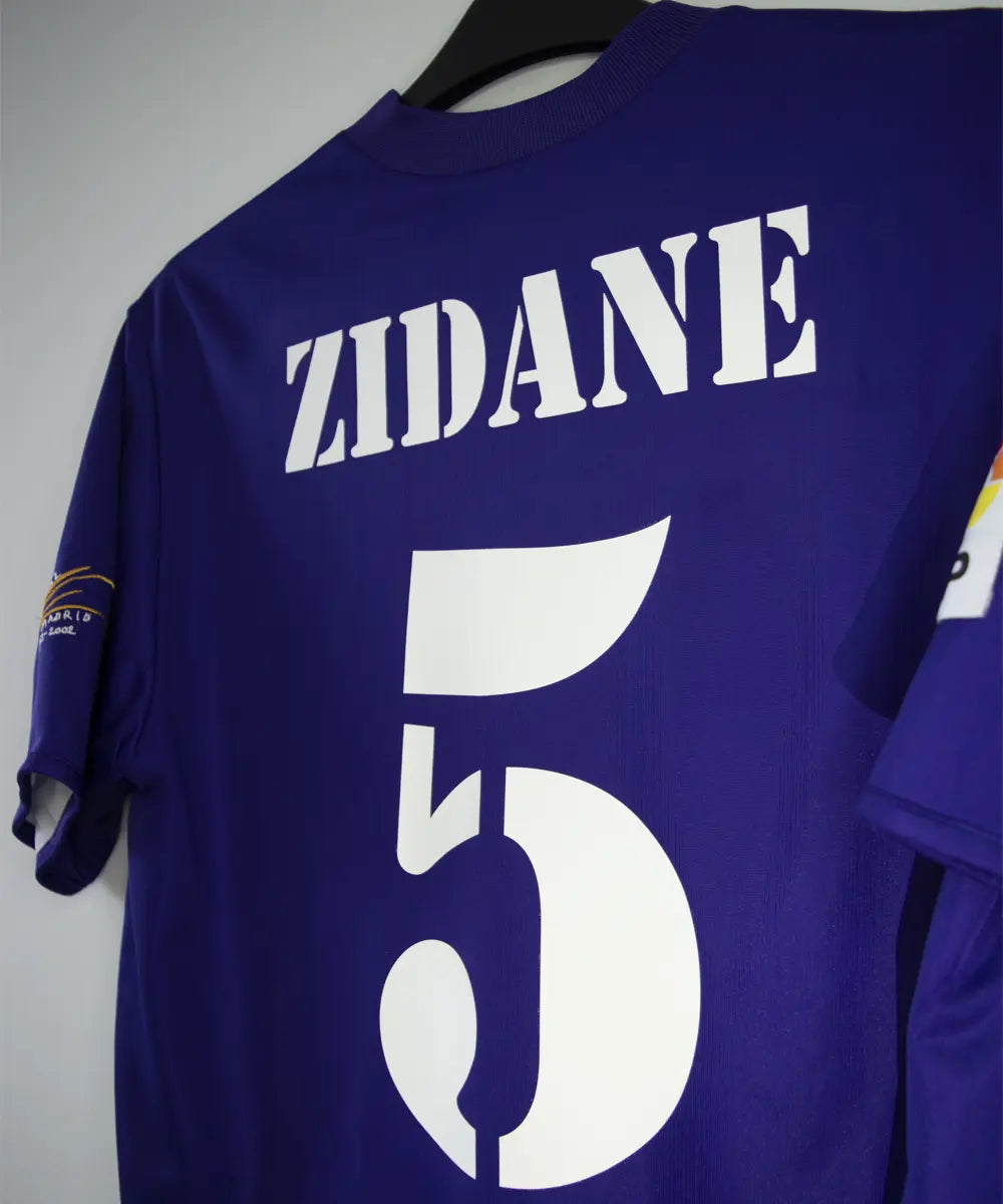 Maillot vintage violet et blanc third du real madrid de la saison 2002-2003. On peut retrouver l'équipementier adidas et le sponsor siemens mobile. Il s'agit du maillot du centenaire. Le maillot est floqué du numéro 5 Zinedine Zidane