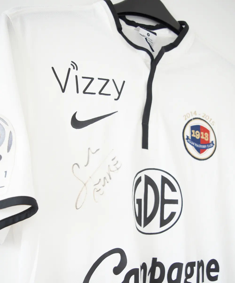 Maillot third du SM Caen de la saison 2014-2015 de couleur blanc et noir. On peut retrouver l'équipementier nike, le sponsor GDE et le sponsor SAS Malus. Le maillot est floqué du numéro 2 Nicolas Seube. Le maillot est aussi signé par Seube