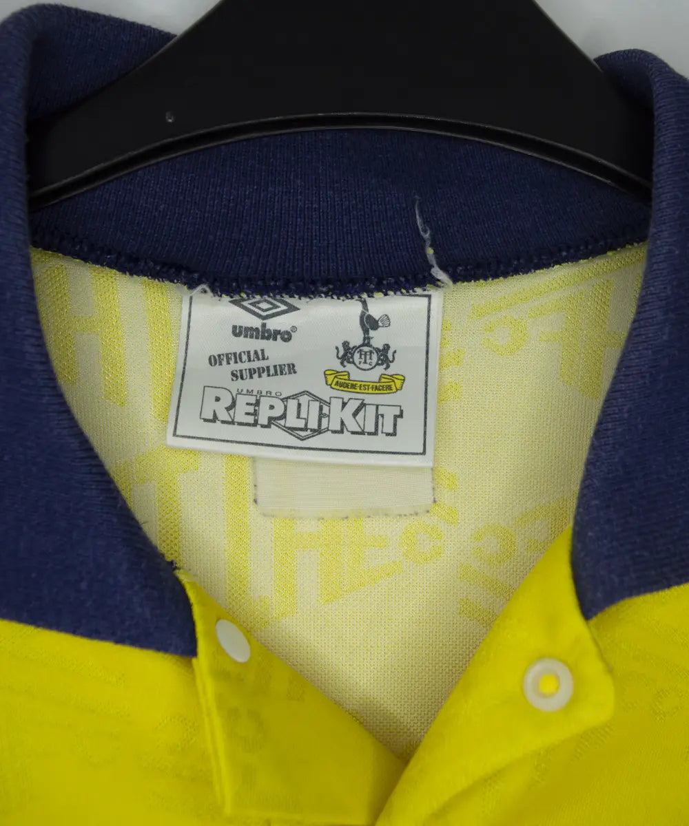 Maillot extérieur de Tottenham de la saison 1991-1995 de couleur jaune. On peut retrouver l'équipementier Umbro et le sponsor Holsten