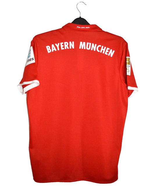 Maillot domicile du bayern munich rouge et blanc porté lors de la saison 2016-2017. On peut retrouver sur le maillot l'équipementier adidas ainsi que le sponsor Deutsche Telekom