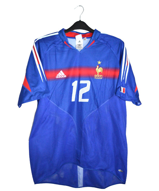 Maillot domicile bleu de l'équipe de france 2004-2006. Sur le maillot on peut retrouver l'équipementier adidas. Le maillot est floqué du numéro 12 Thierry Henry.